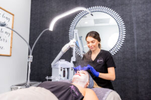 A female Karma Beauty & Wellness esthetician administers a custom Karma Facial to a female patient at our wellness clinic in Overland Park.